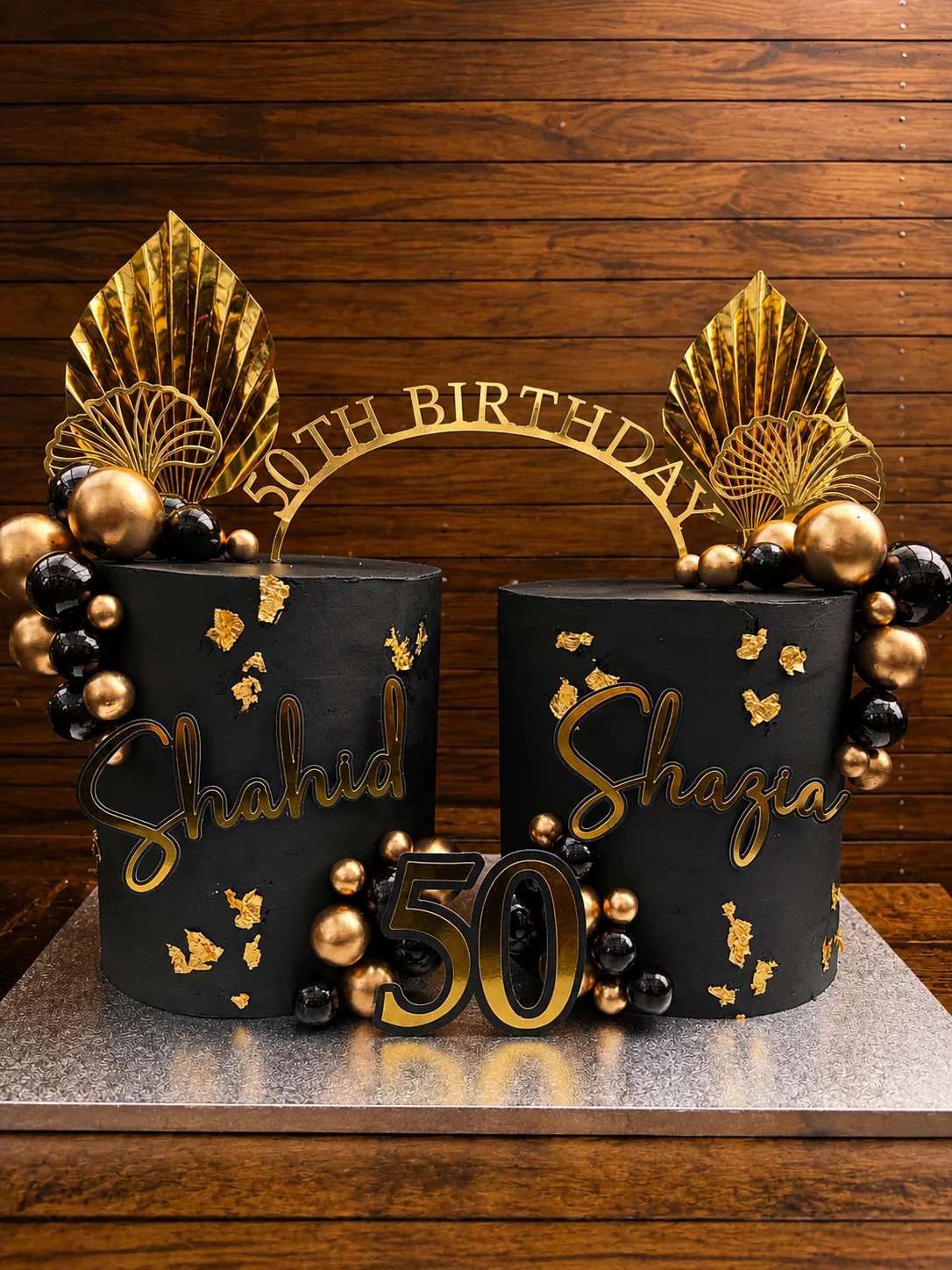 Two black and gold cakes made for a 50th birthday