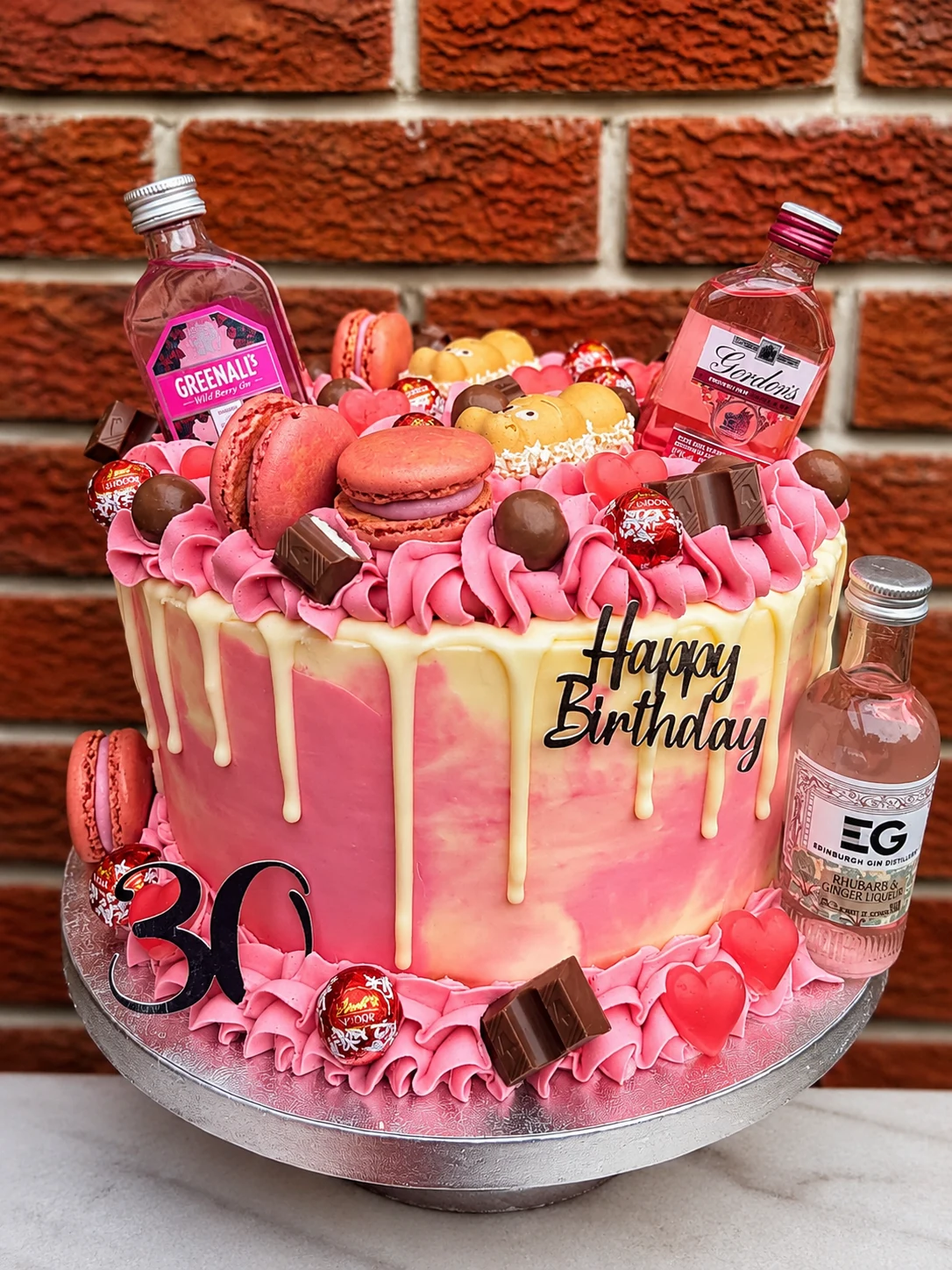 A pink birthday cake decorated with macarons and chocolates